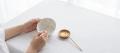 Hands repairing a white ceramic bowl with fine gold seams, representing restitution for property damage