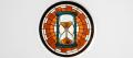 Round stained-glass window of an hourglass with amber sand running down, framed by burnt-orange panes