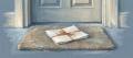 Soft pastel drawing on blue-grey paper of folded papers tied with an orange ribbon resting on a doormat at a front door