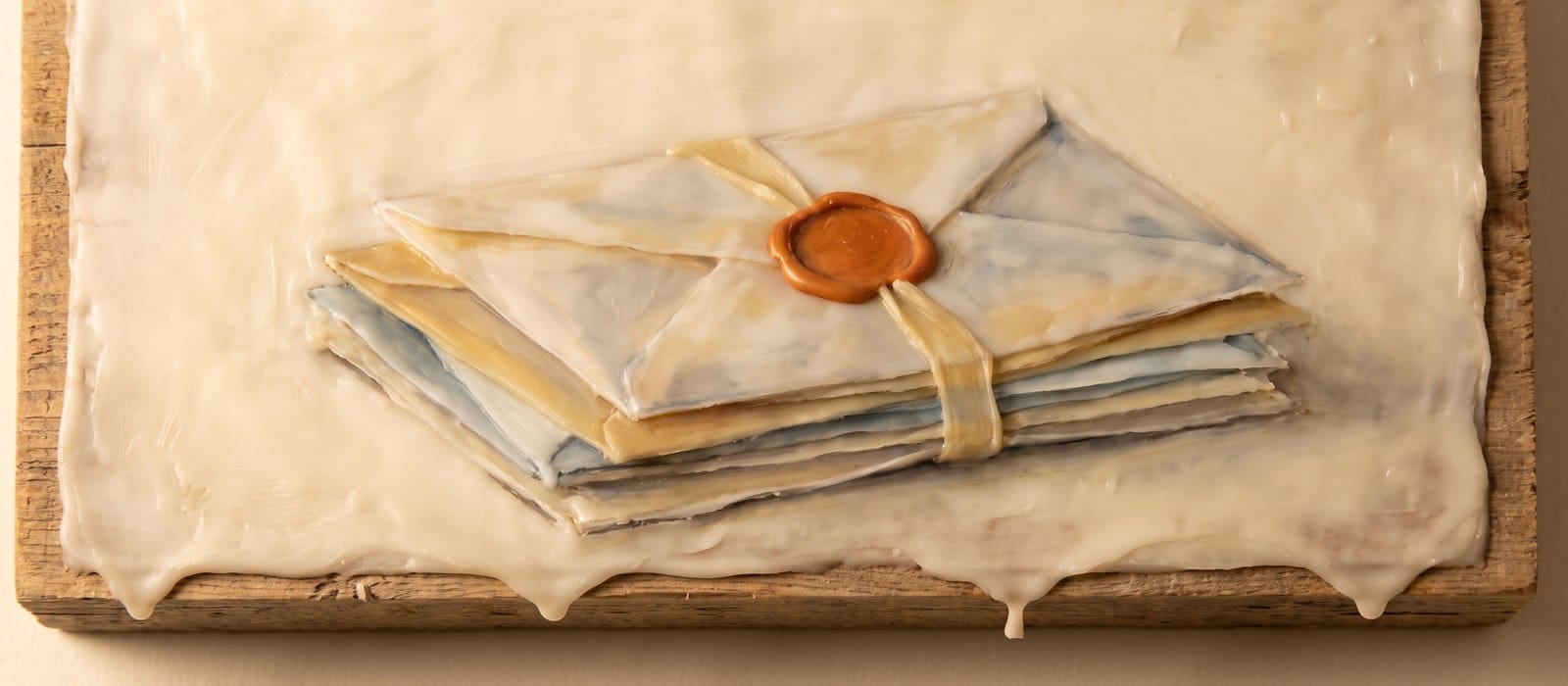 Encaustic wax painting of a stack of sealed envelopes tied with a pale gold ribbon and closed with an orange wax seal