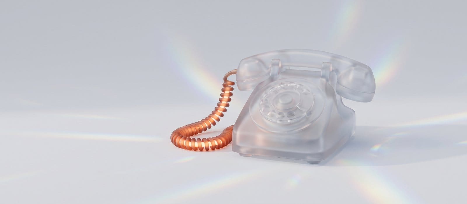 Frosted glass rotary telephone with a glowing orange cord on a pale background