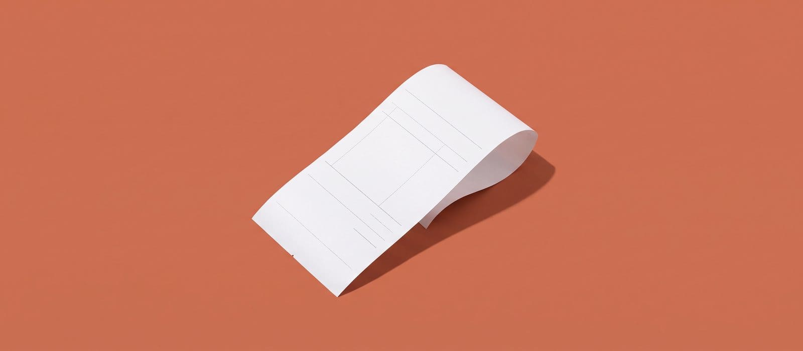 A folded blank white retail receipt on a terracotta backdrop, representing diversion and restitution in a shoplifting case
